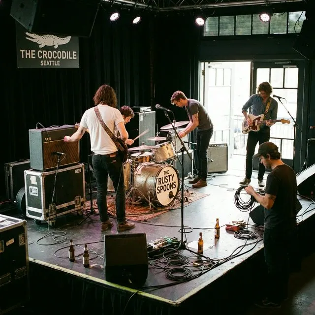 A band setting up gear on stage before a gig